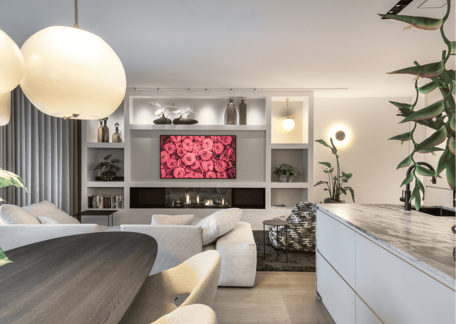 Interieur van een moderne woning met een open keuken en woonkamer, voorzien van een kaarsrecht, wit naadloos akoestisch plafond van Pennings voor een rustige leefomgeving.