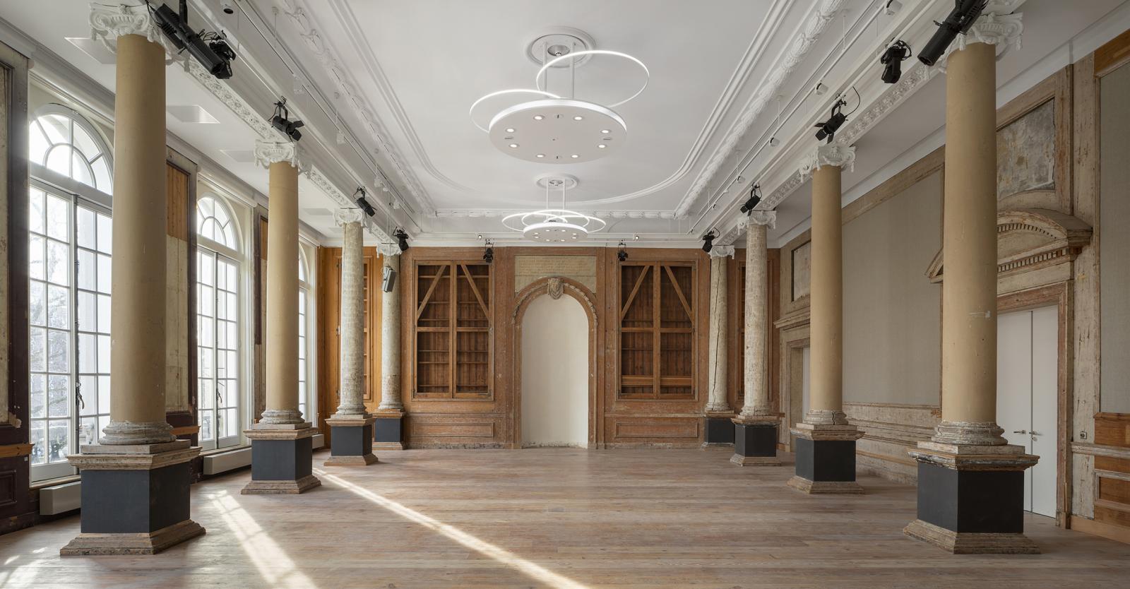 Close-up van een naadloos akoestisch plafond met een strakke, witte structuur die niet te onderscheiden is van regulier stucwerk, maar beschikt over maximale geluidsabsorptie.