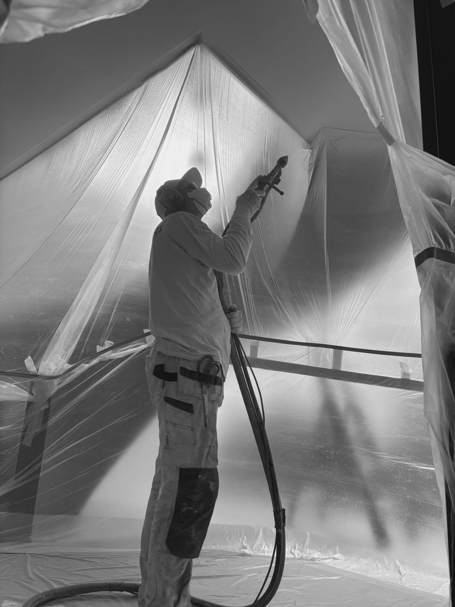 Een gecertificeerde vakman van Pennings Akoestiek is bezig met de nauwkeurige applicatie en afwerking van een naadloos akoestisch plafond, werkend volgens de strikte TBA-richtlijnen voor een krimpvrij resultaat.